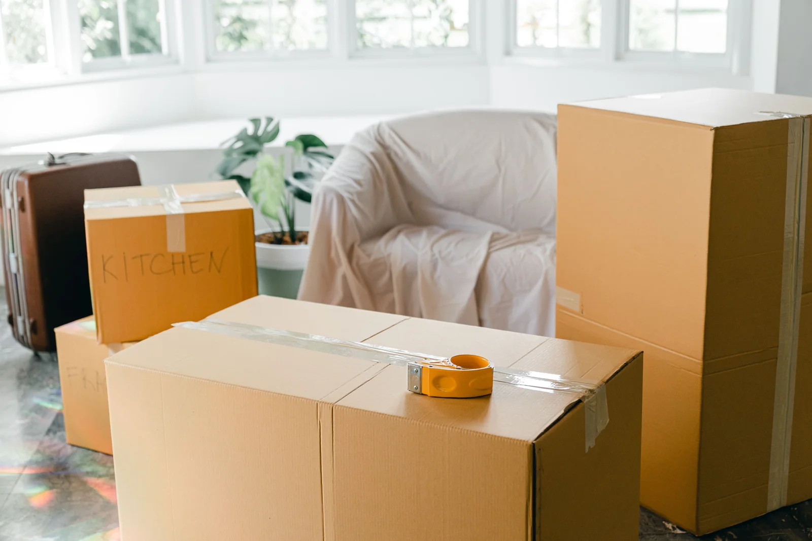Pièce lumineuse avec mobilier protégé et cartons prêts pour un déménagement